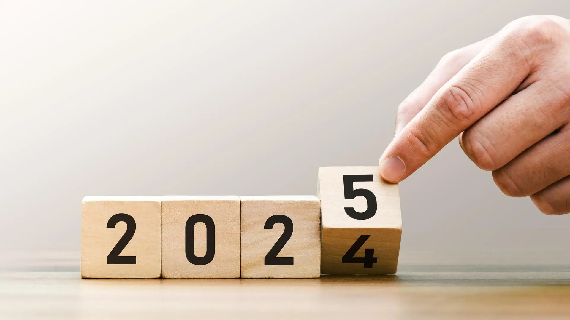 Transitioning from 2024 to 2025 with wooden blocks symbolizing target business for the upcoming year. This represents planning, investment, and innovation as ideas move from the end of 2024 new year